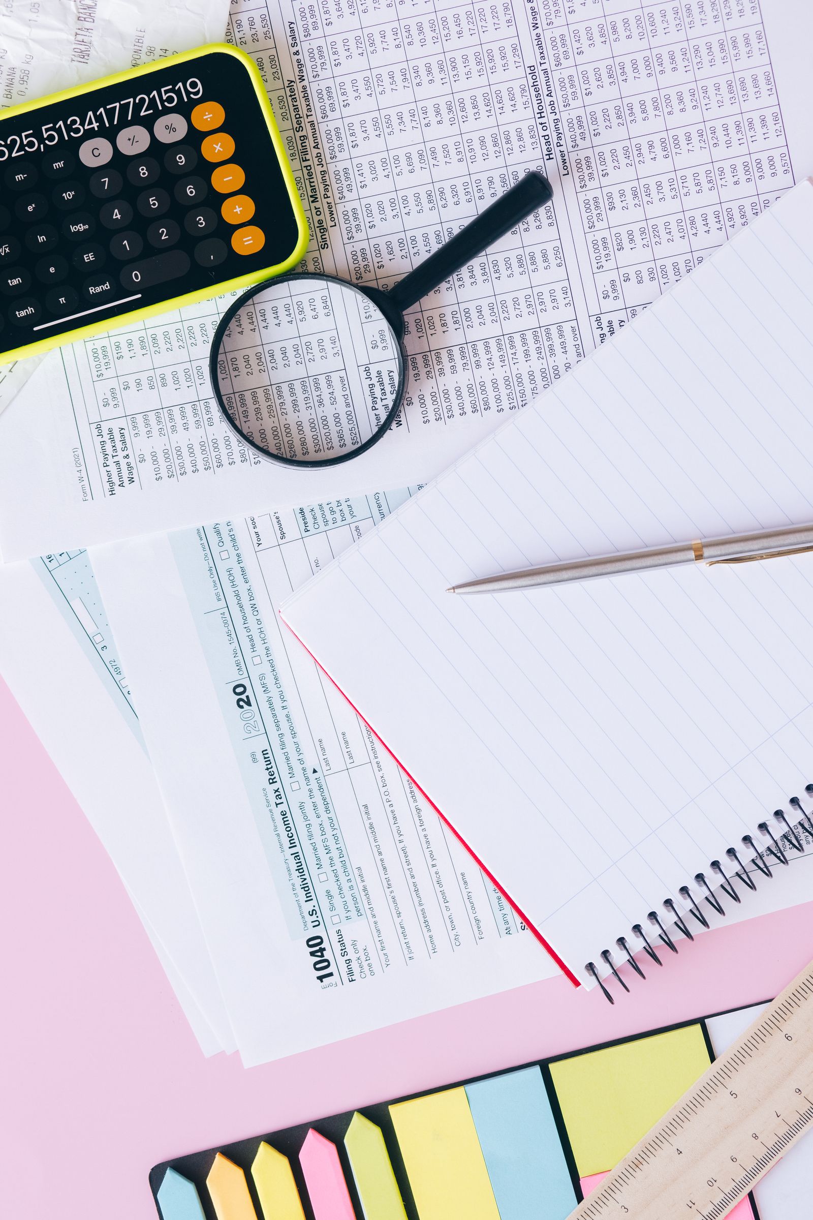 Tax return documents under review with a magnifying glass